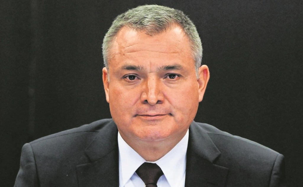 Retrato de un hombre de negocios con traje oscuro y corbata, frente a un fondo oscuro.