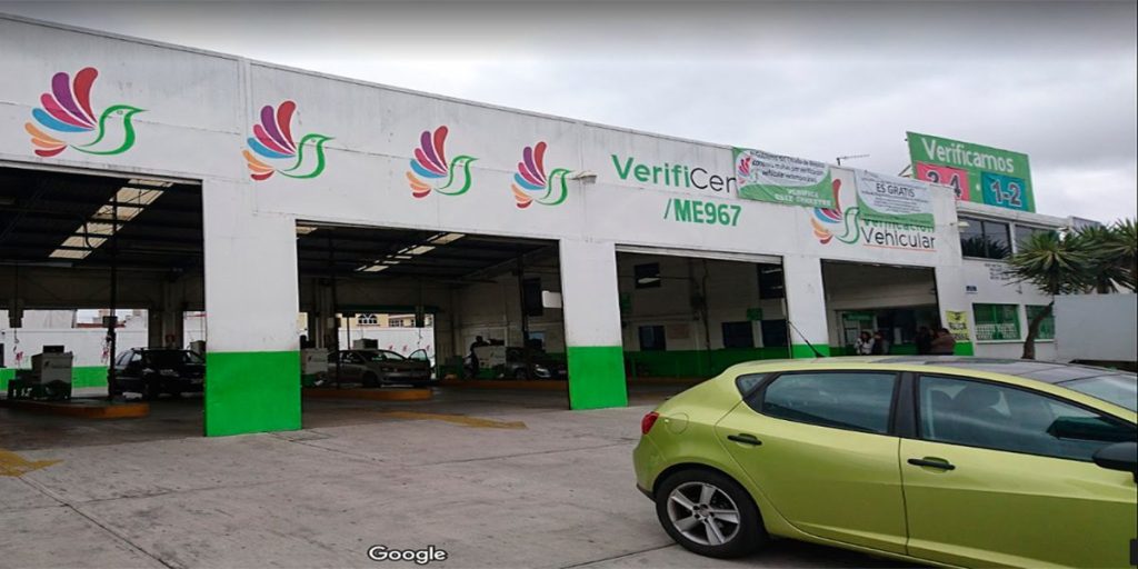 Automóvil verde saliendo de un verificentro