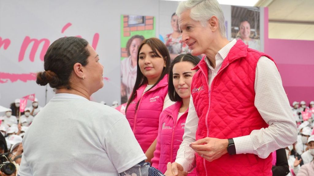 Alfredo del Mazo entregando tarjeta rosa a una mujer