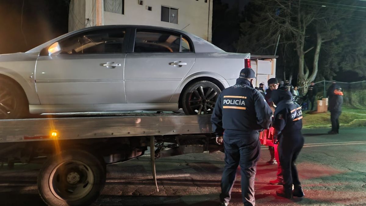 Auto en grúa y policías municipales de Toluca