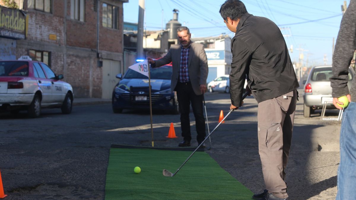 Dos personas "jugando" golf sobre baches