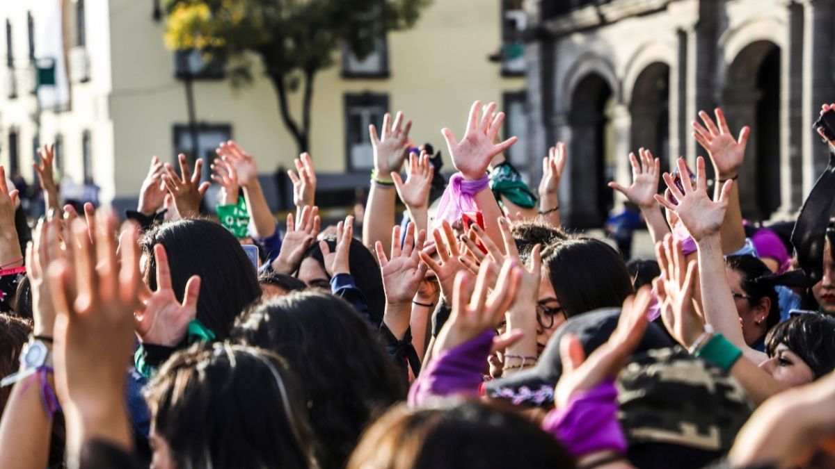 Mujeres levantando las manos en marcha feminista en Toluca
