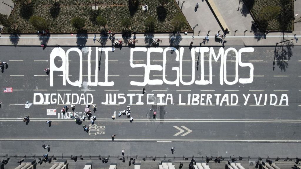 "Aquí seguimos" escrito sobre la calle frente a Palacio de Gobierno de Toluca