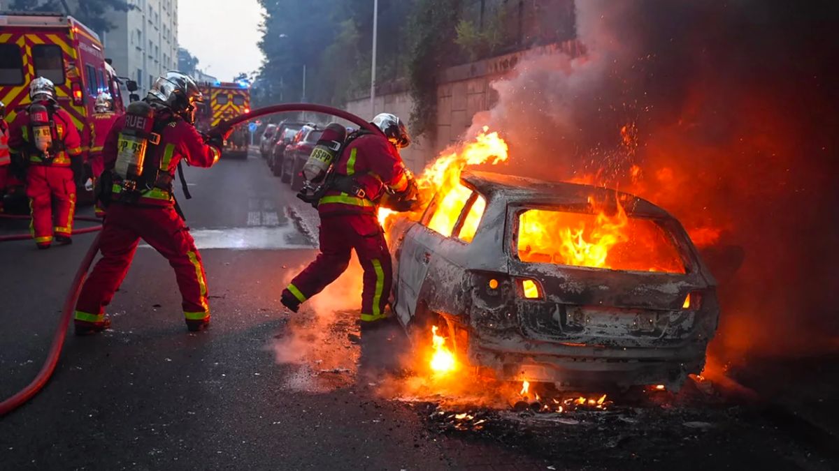 Bomberos apagando incendio de automóvil que dejó protesta en Francia