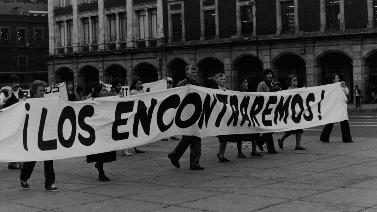 Personas protestando con una manta que dice: "¡Los encontraremos!"