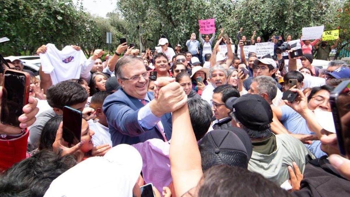 Marcelo Ebrard con gente saliendo del INE tras pagar multa