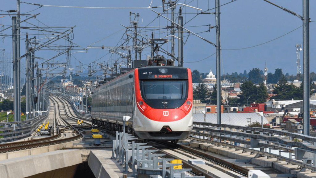 A modern train traveling on an elevated track with a cityscape in the background.
