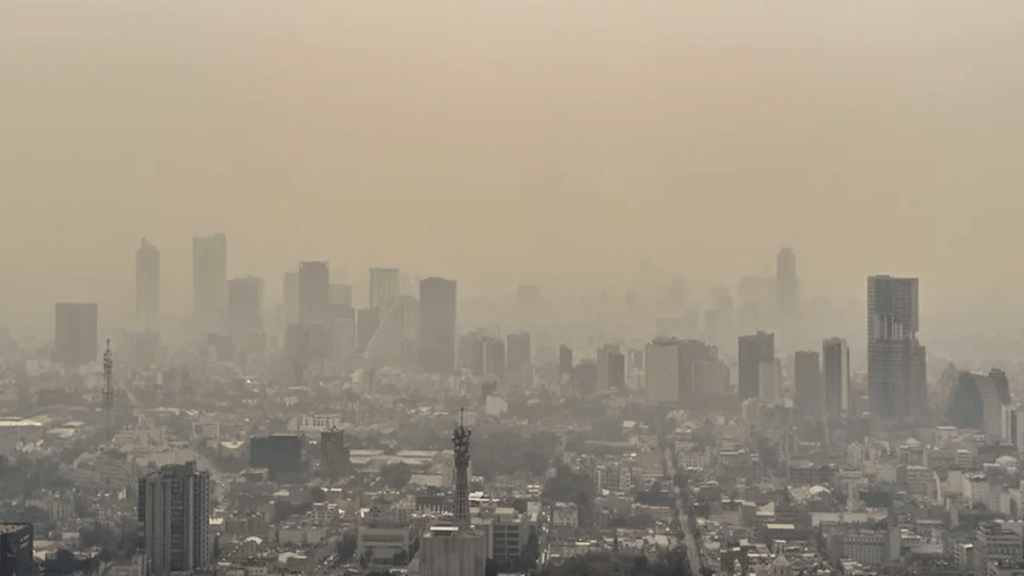 Vista de la contaminación atmosférica en el Valle de Toluca, con una neblina espesa sobre la ciudad y los edificios parcialmente visibles.