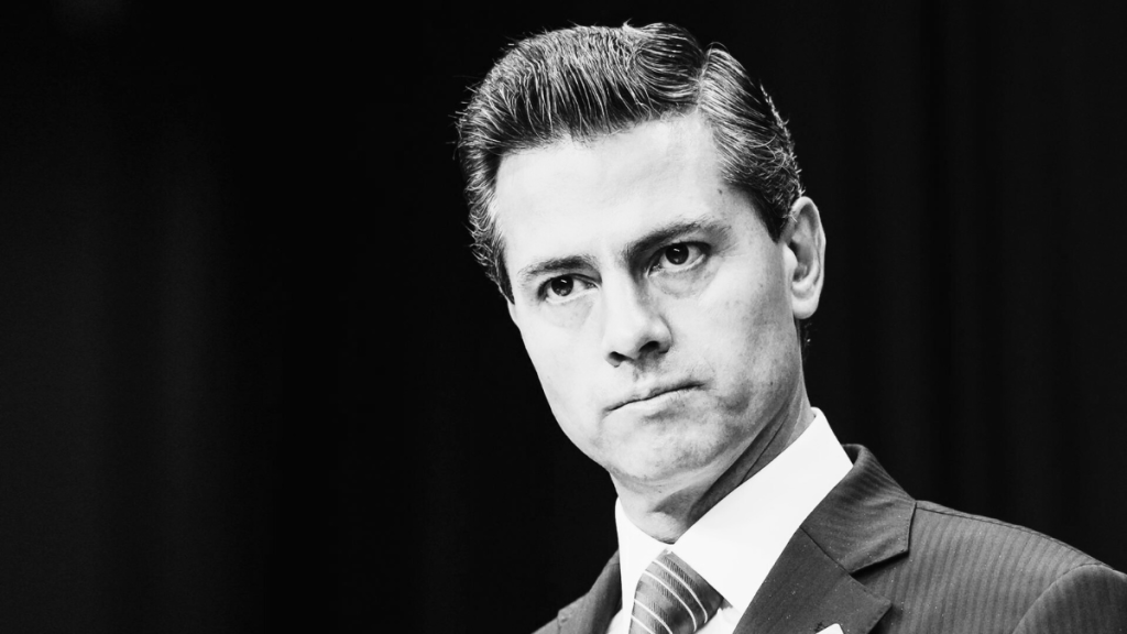 Retrato en blanco y negro de un hombre de negocios con un cabello bien peinado, luciendo serio y vestido con traje.