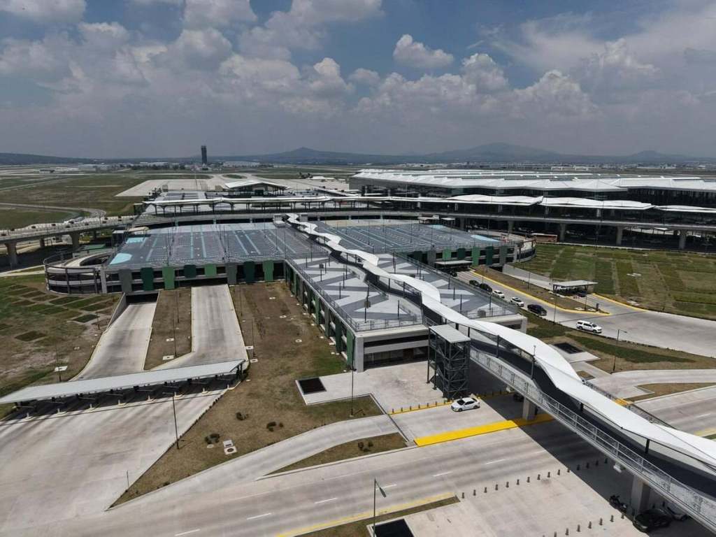 Vista aérea de un aeropuerto moderno con una estructura de techado ondulante y un estacionamiento en primer plano.