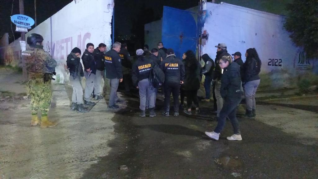 Agentes de seguridad y autoridades en un sitio durante un operativo nocturno, con un enfoque en la vigilancia y el control de la situación.