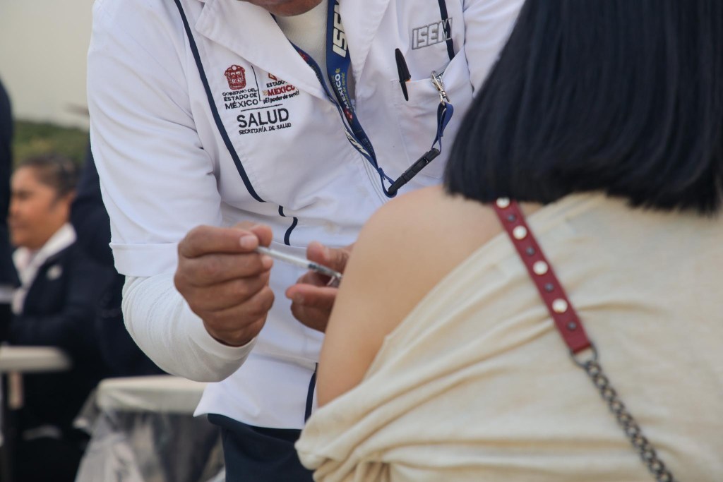 A healthcare professional administering a vaccination to a patient in an outdoor setting.