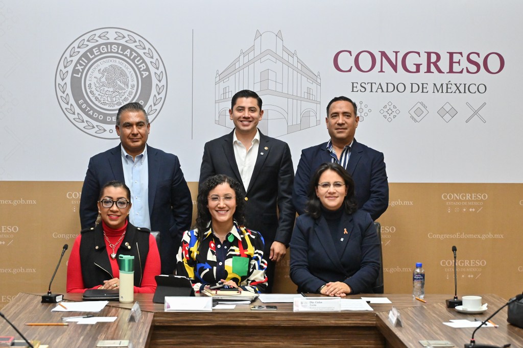 Retrato de seis legisladores en una reunión del Congreso del Estado de México, con un fondo que muestra el emblema del congreso.