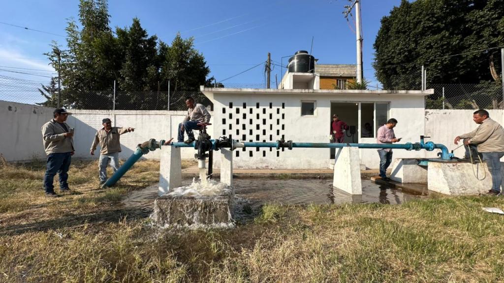 Operarios realizando mantenimiento en un pozo de agua en la colonia Luis Echeverría, Cuautitlán Izcalli, con un sistema hidráulico en funcionamiento.