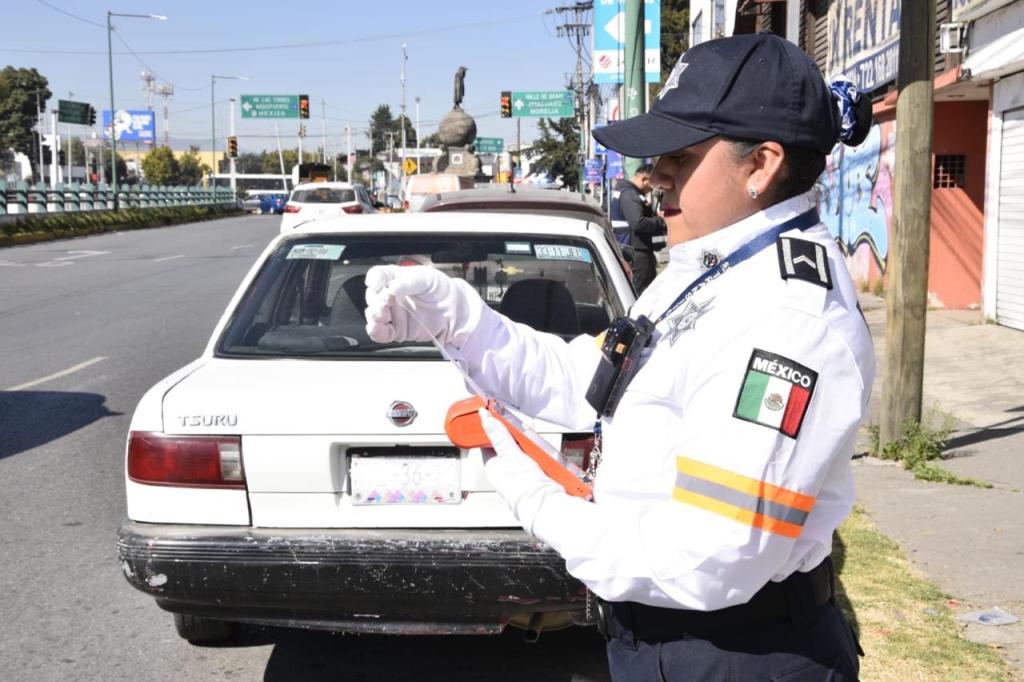 Agente de tránsito emitiendo una infracción a un vehículo en una calle de la ciudad.
