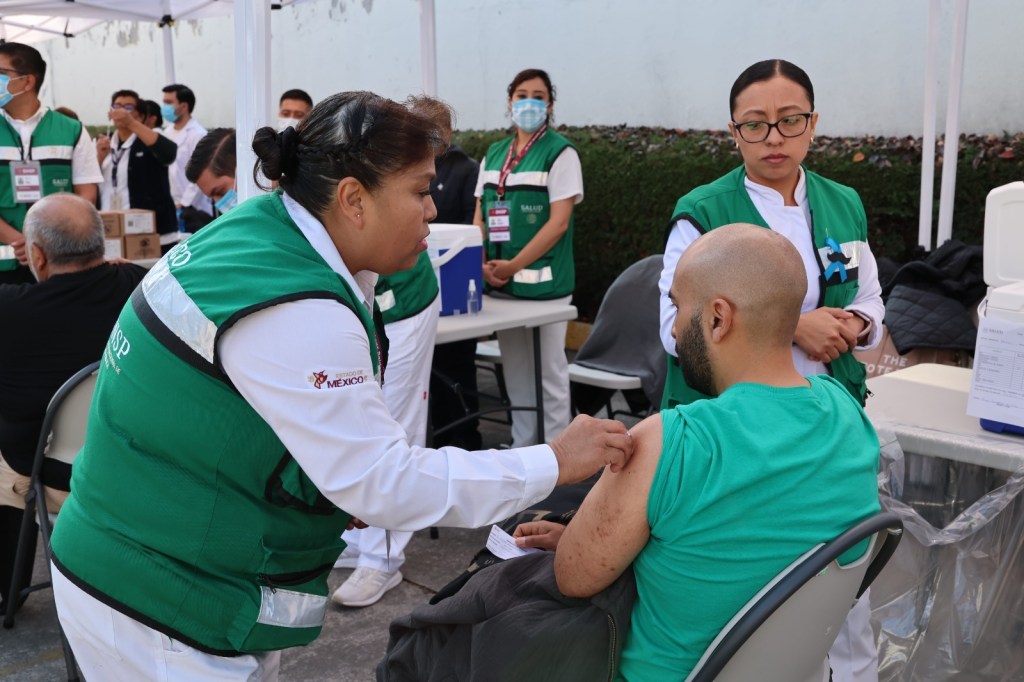 Una trabajadora de salud administra una vacuna a un hombre en un evento de vacunación en el Estadio de Fútbol Americano 'Lic. Juan Josafat Pichardo Cruz'.