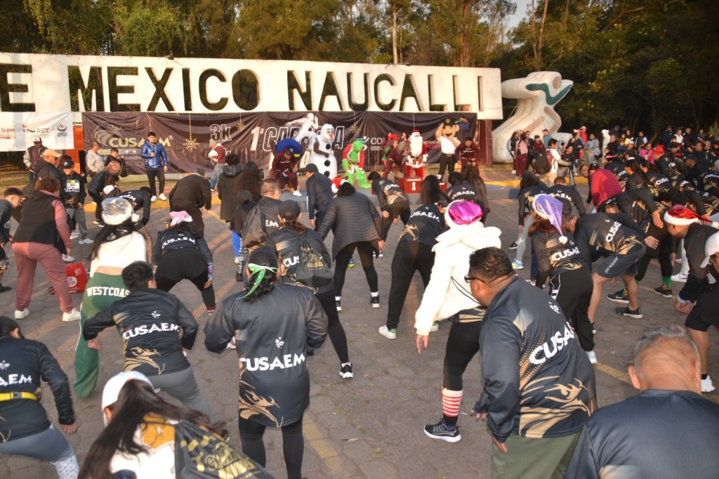 Participantes calentando antes de la Primera Carrera Atlética Navideña 2025 organizada por CUSAEM en el Parque Naucalli.
