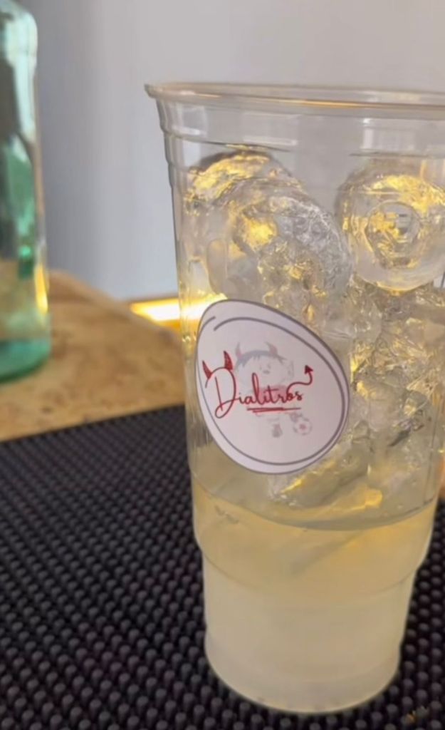 Vaso transparente con hielo y bebida, con etiqueta de 'Dialitros'.