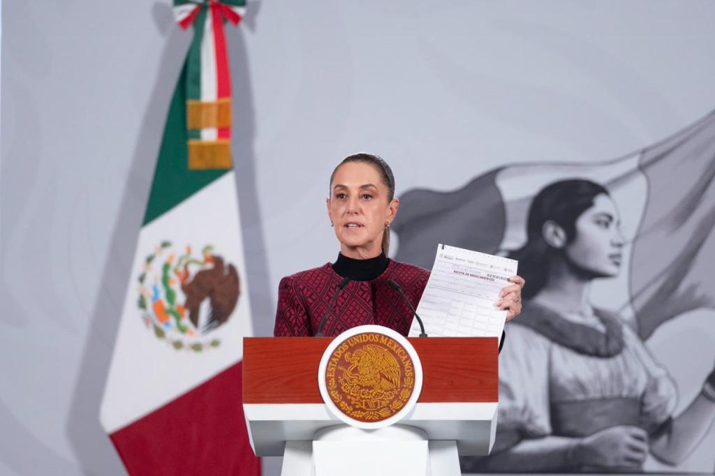 Funcionaria del gobierno presentando las Farmacias del Bienestar, con fondo de bandera mexicana y una imagen de una mujer.