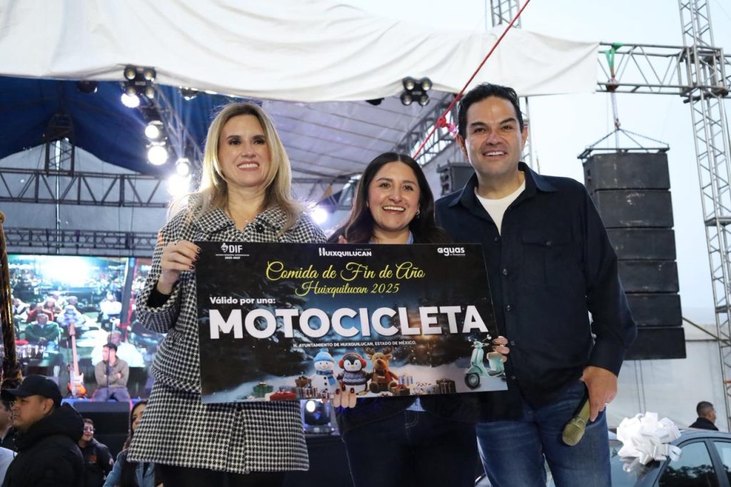 Tres personas sosteniendo un cartel que anuncia una rifa de motocicleta durante un evento de fin de año en Huixquilucan, con un fondo de escenario y luces.