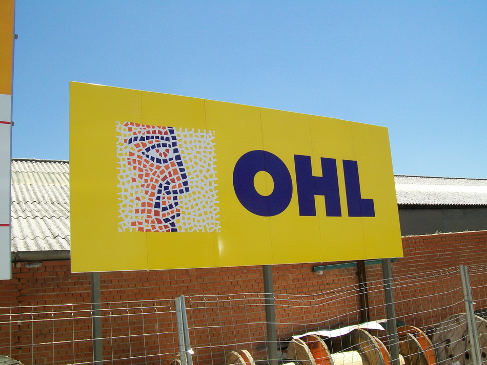Cartel publicitario de la empresa OHL, con un diseño en colores amarillo y azul, que incluye un rostro estilizado en mosaico.