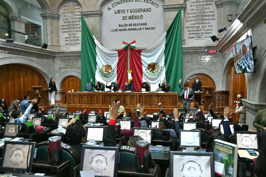 Pleno del Congreso del Estado de México con diputados levantando la mano para votar, en una sesión legislativa.
