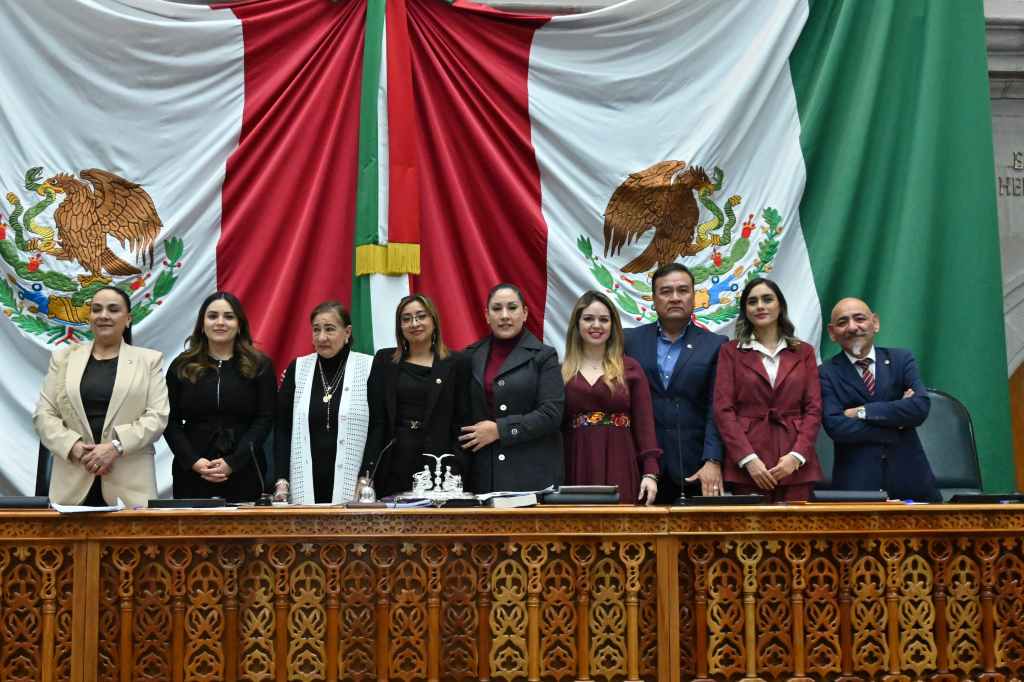 Grupo de legisladores posando frente a una bandera de México en el Congreso del Estado de México.