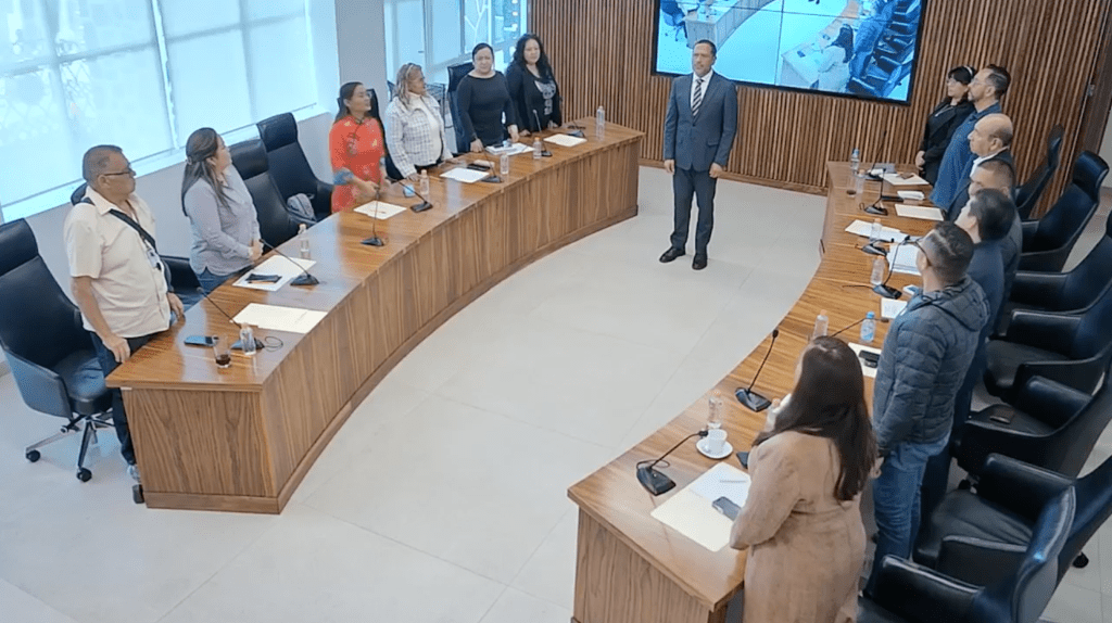 Reunión del Cabildo de Tecámac con varios miembros de la administración municipal presentes, en un ambiente formal. Se observa al nuevo secretario del Ayuntamiento y a la tesorera municipal en el centro de la mesa.