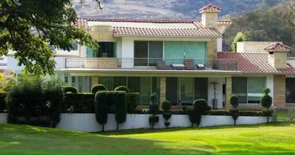 Vista exterior de una casa contemporánea en Ixtapan de la Sal, México, rodeada de áreas verdes y arbustos bien recortados.