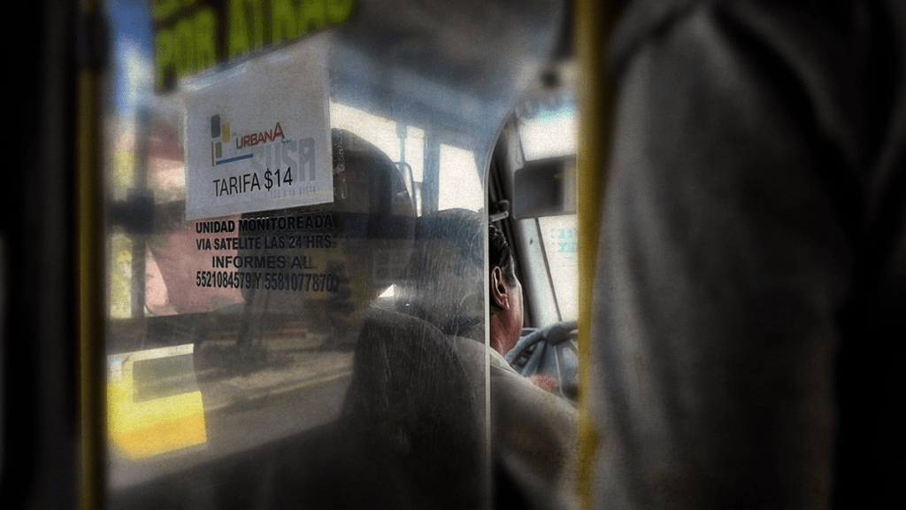 Vista parcial del interior de un transporte público en el Valle de Toluca, mostrando un letrero con la tarifa actual de $14 y un conductor al volante.