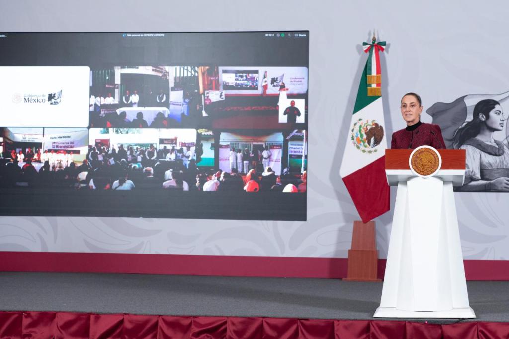 La presidenta Claudia Sheinbaum presenta el programa Farmacias del Bienestar en un evento respaldado por banderas de México y un amplio público en pantallas múltiples.
