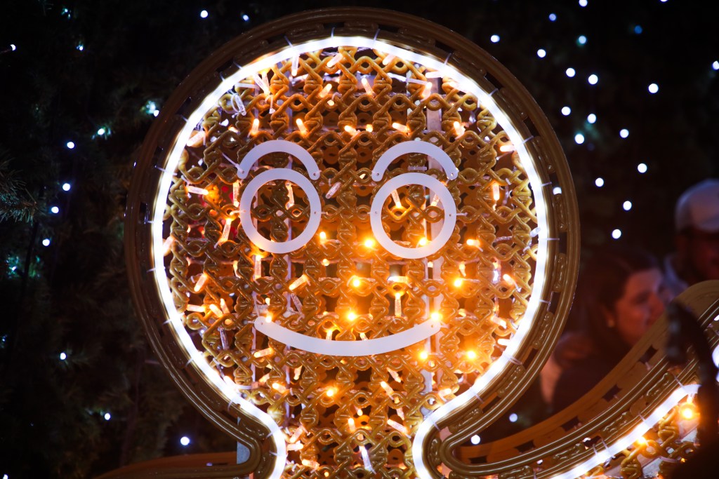 Luz navideña en forma de un muñeco de jengibre con luces brillantes de fondo.