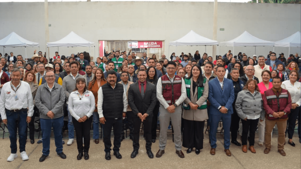 Grupo de personas reunidas en un evento de salud, con algunos miembros del gobierno visibles en el primer plano.