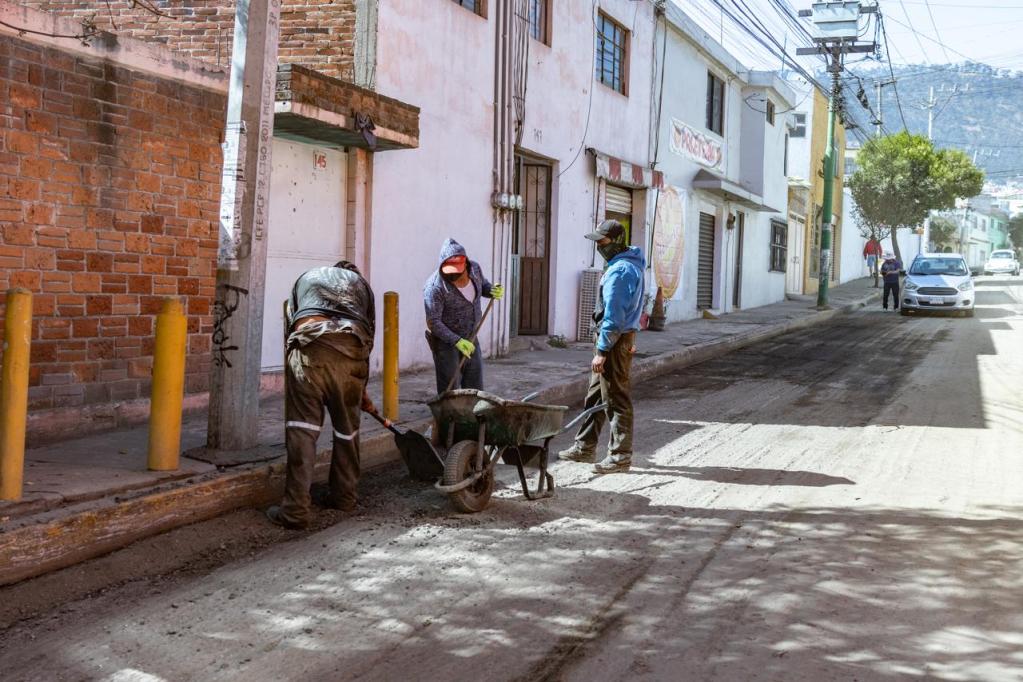 Trabajadores realizando labores de pavimentación en la calle Prolongación 18 de Marzo, con maquinaria y herramientas, mientras mejoran el acceso a los servicios básicos.