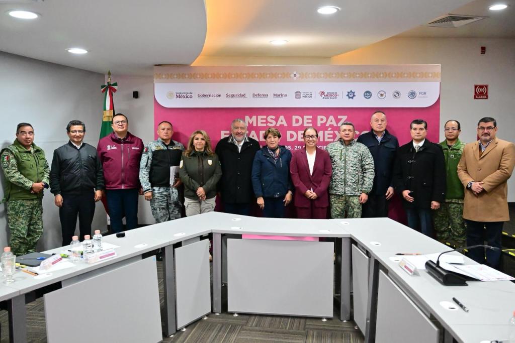 Grupo de autoridades y representantes de seguridad en la Mesa de Paz en Ecatepec, México, posando frente a un fondo rosa con el logo del gobierno.