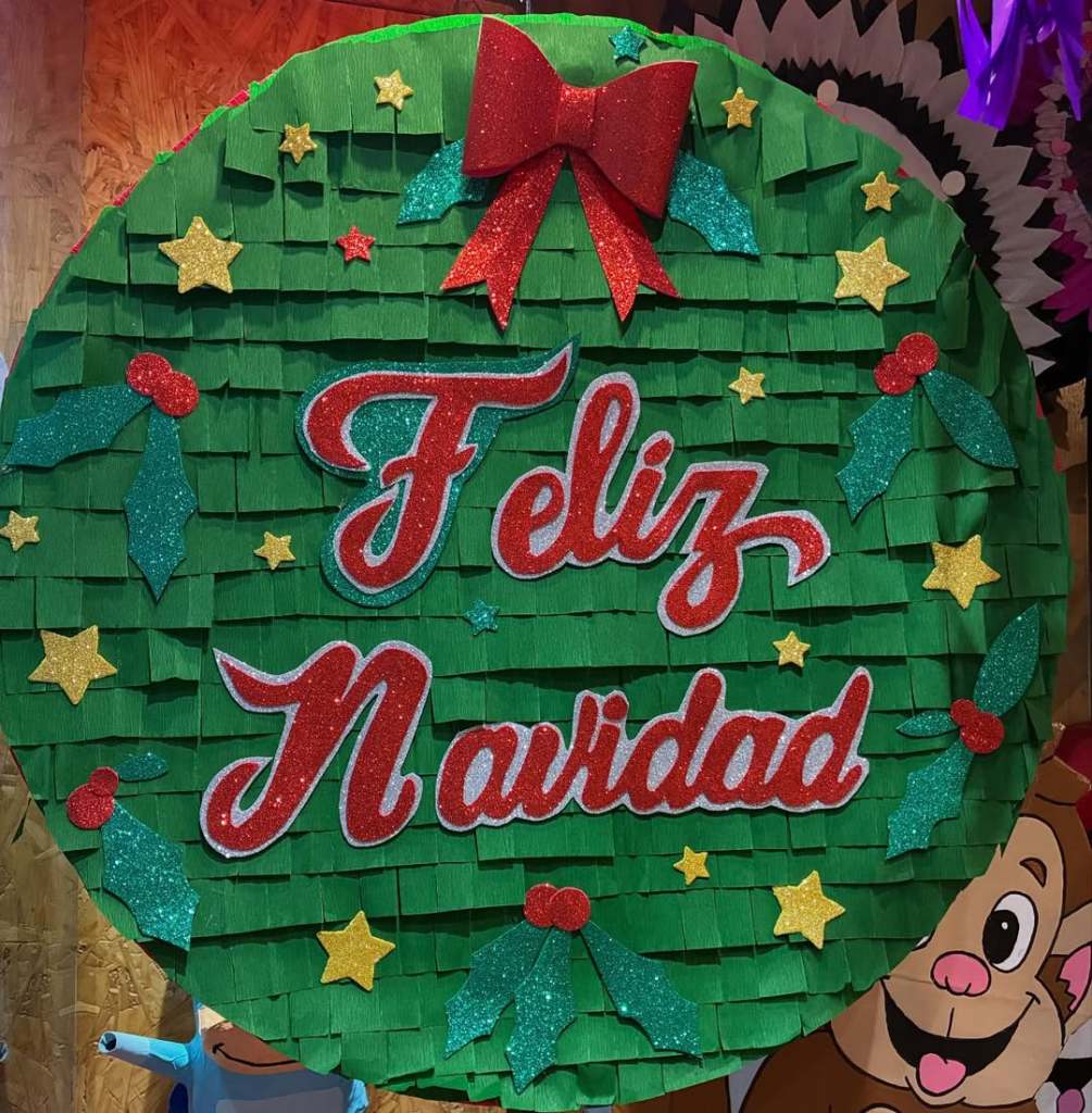 Piñata decorada para Navidad con el texto 'Feliz Navidad' en letras coloridas y adornos navideños.