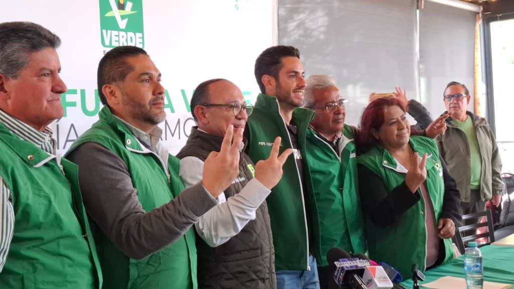 Grupo de personas con chalecos verdes del Partido Verde Ecologista de México (PVEM) posando durante un evento político en Zinacantepec, México.