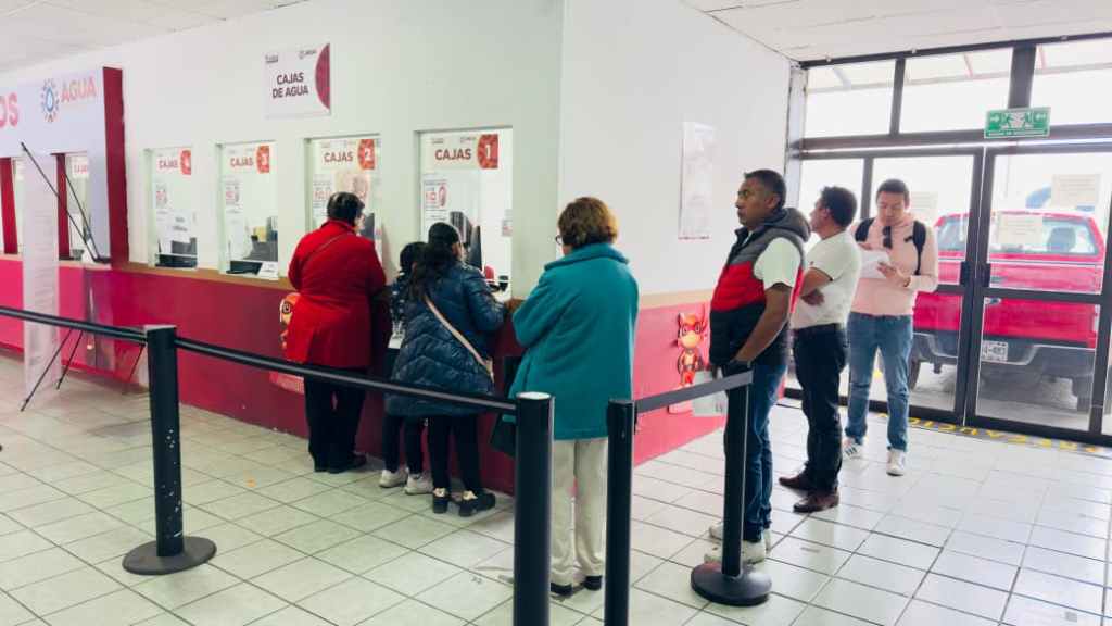 Cliente en la oficina de atención y cobro del Organismo Agua y Saneamiento, haciendo fila para realizar el pago anual del servicio de agua.