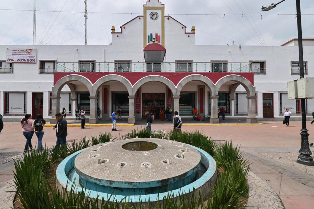 Edificio del Congreso del Estado de México con arquitectura característica, rodeado de plantas y visitantes en el área exterior.