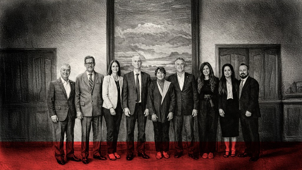 Grupo de personas posando en un entorno interior, con un cuadro paisajístico de fondo.