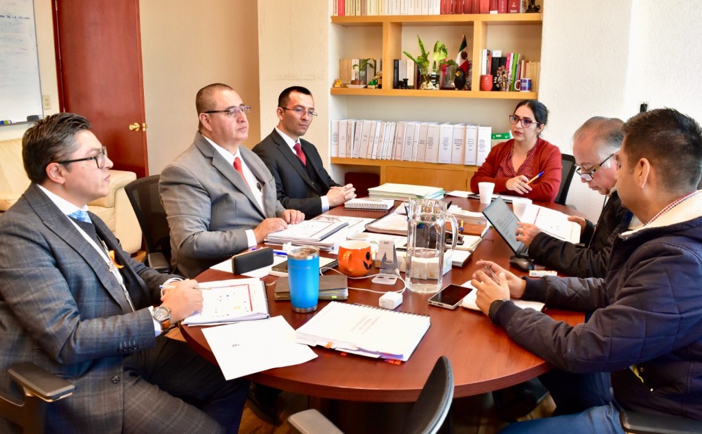 Reunión del equipo de la Secretaría de la Contraloría del Estado de México, discutiendo estrategias y resultados en un entorno profesional.