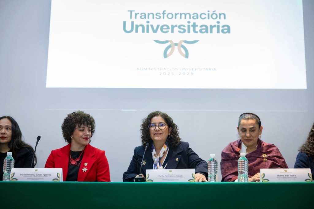 Panel of four women sitting at a table during a conference on university transformation, with a presentation backdrop displaying 'Transformación Universitaria' and 'Administración Universitaria 2025-2029'.