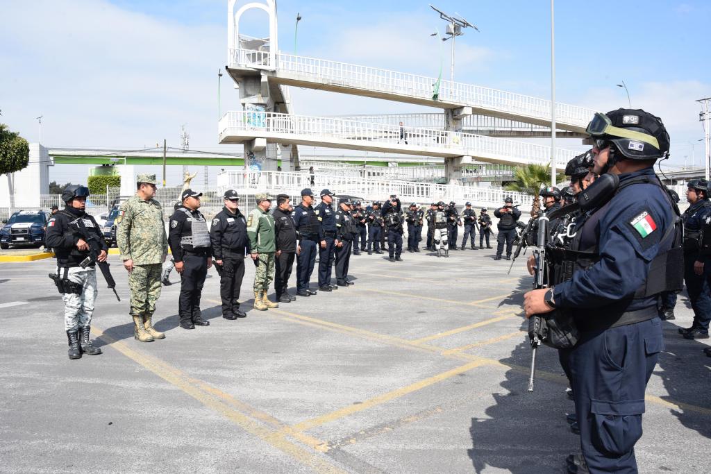 Un grupo de policías y militares formando filas durante un ejercicio de coordinación en un espacio público.