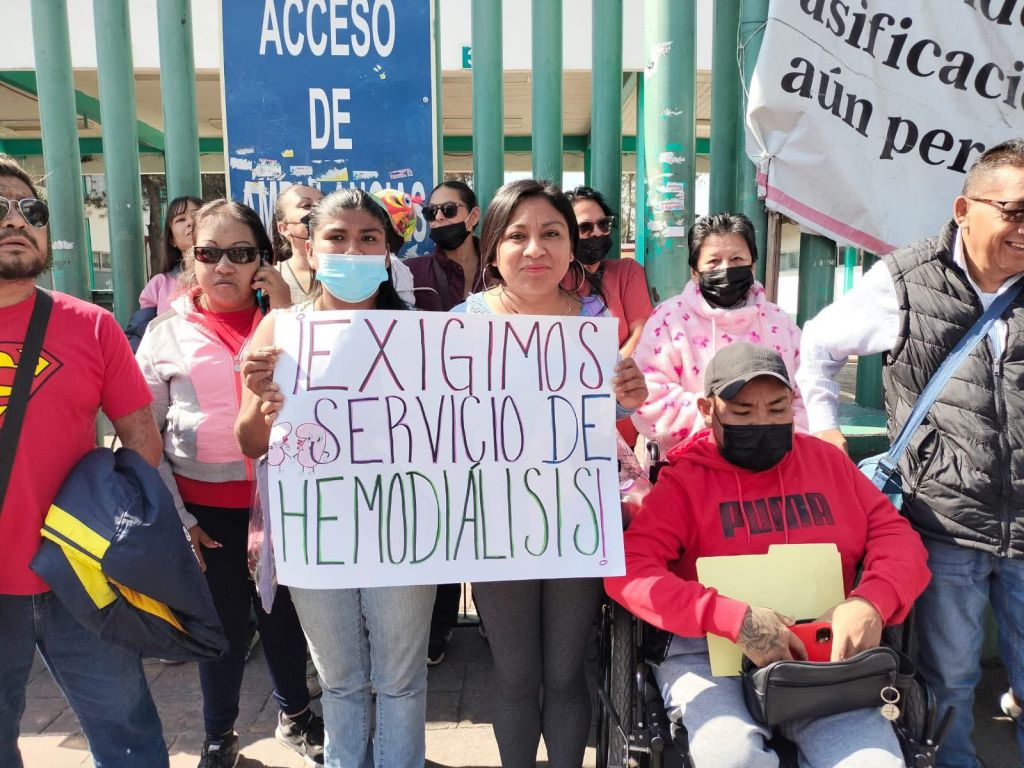 Grupo de personas en una manifestación, sosteniendo un cartel que dice 'EXIGIMOS SERVICIO DE HEMODIALISIS'.