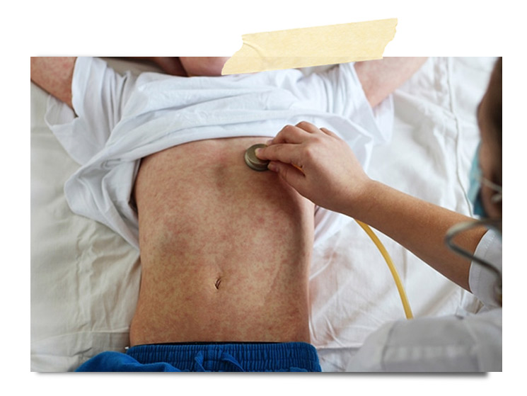 Examen médico de un niño con un estetoscopio sobre su abdomen.