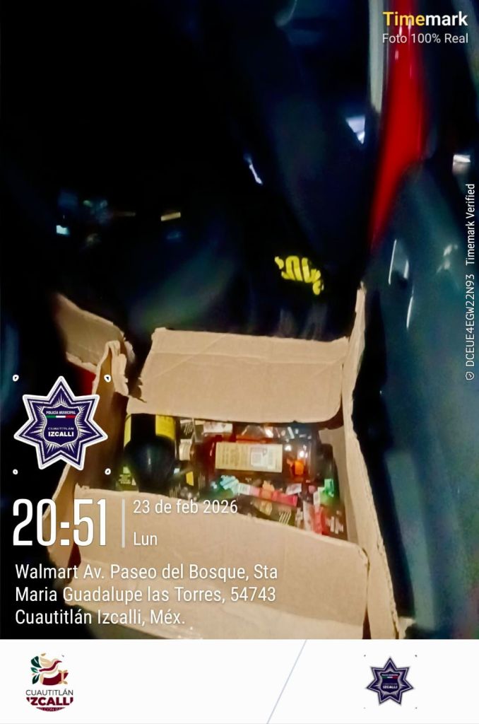 Una caja abierta con varios productos de belleza y cuidado personal, en un entorno oscuro cerca de un vehículo.