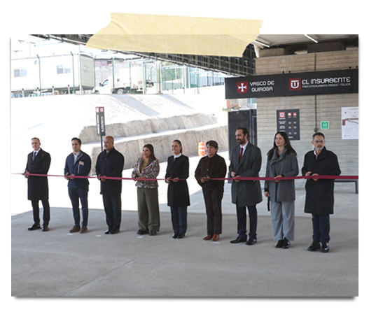 Inauguración de un evento con varias personas sosteniendo una cinta roja, en un espacio industrial.