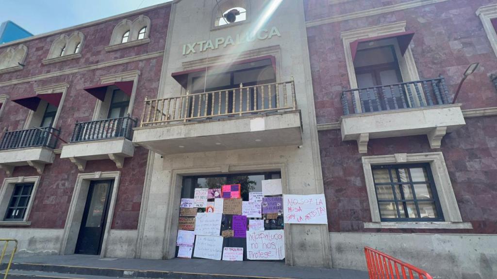 Fachada de un edificio con letreros y pancartas en la entrada, en Ixtapaluca.