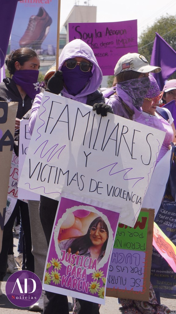 Participantes en una protesta sosteniendo carteles sobre familiares y víctimas de violencia, con un enfoque en la justicia para Karen.