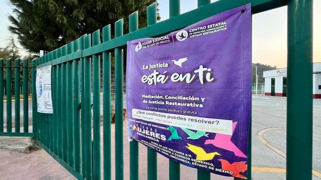 Cartel en una reja que promueve mediación y justicia restaurativa en el estado de México. Incluye el texto 'La justicia está en ti' y menciona conflictos que se pueden resolver.